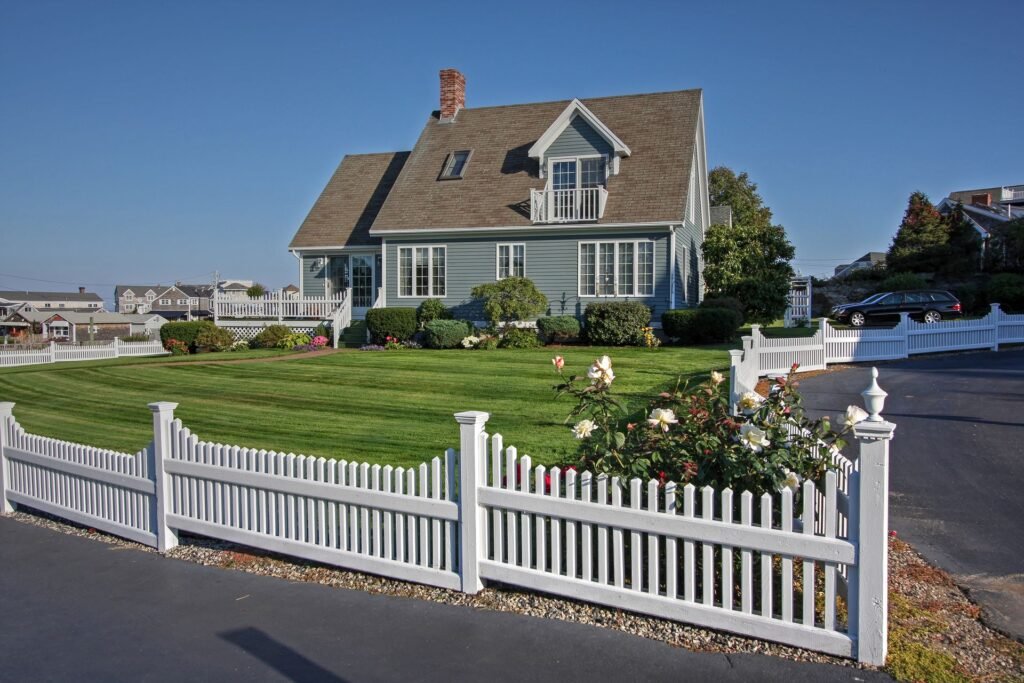 Cape Cod–style home with a lawn and picket fence, typical of Hicksville, NY