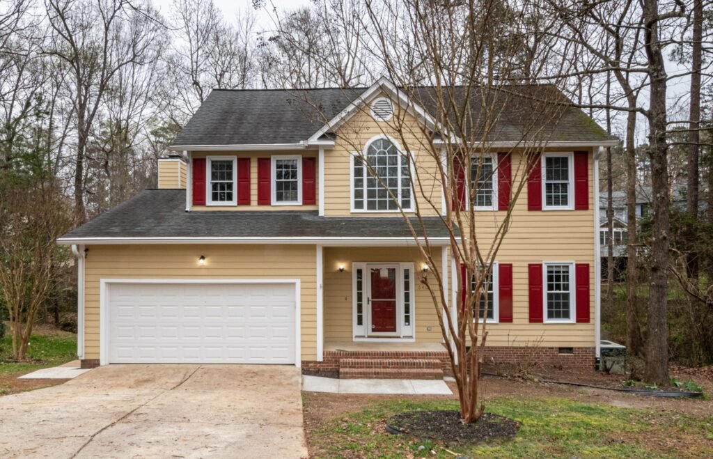 Colonial home with red shutters and garage, similar to homes around Farmingdale, NY