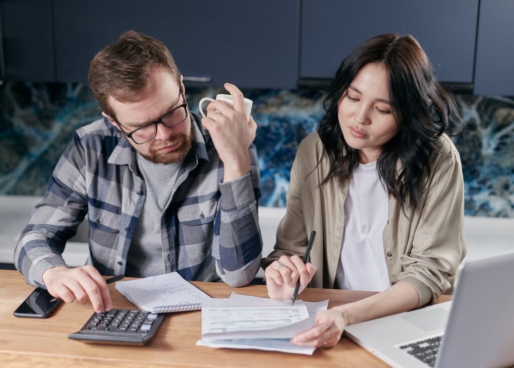 Homeowners reviewing household bills and budget at the kitchen table
