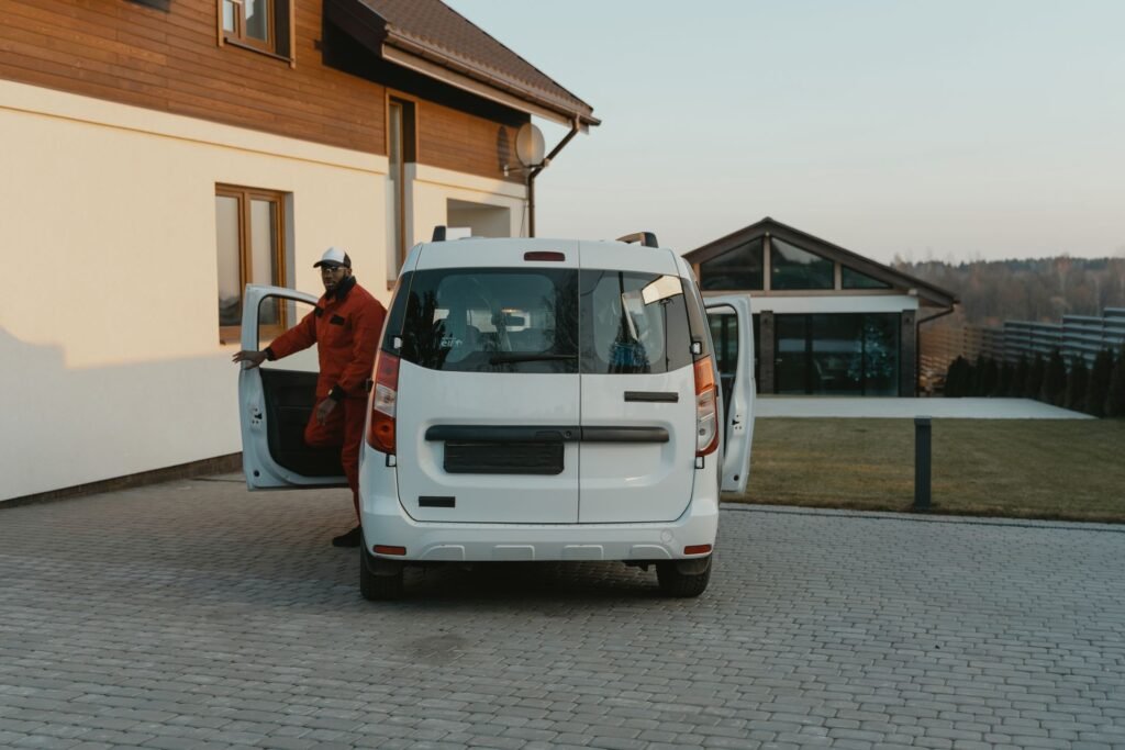 Service technician stepping out of a work van in a residential driveway