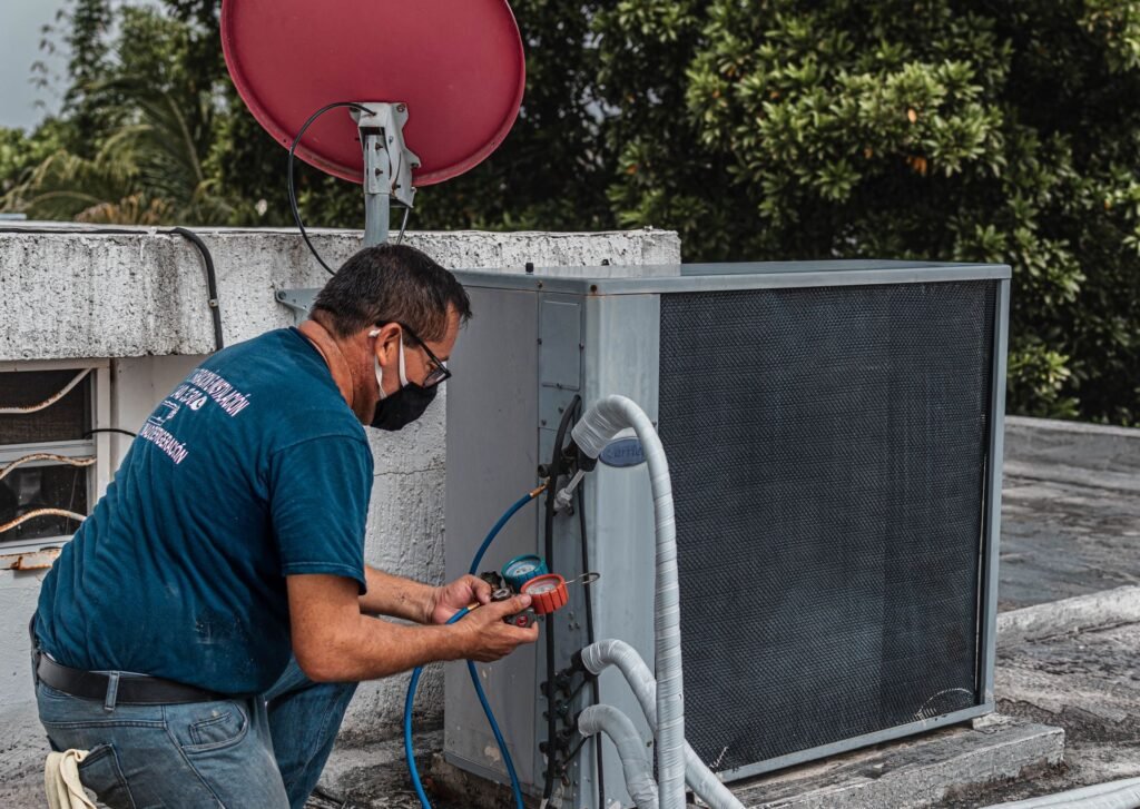 HVAC technician checking an air conditioner with refrigerant gauges
