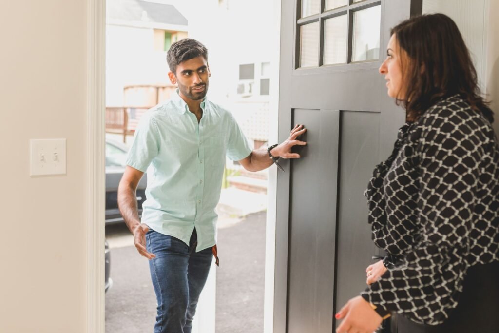 Service technician talking with a homeowner at the front door