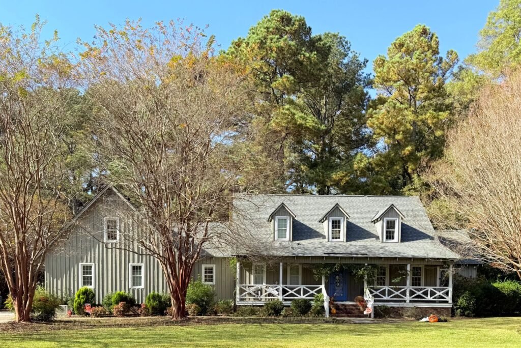Ranch-style home with a front porch among mature trees, typical of Old Bethpage, NY