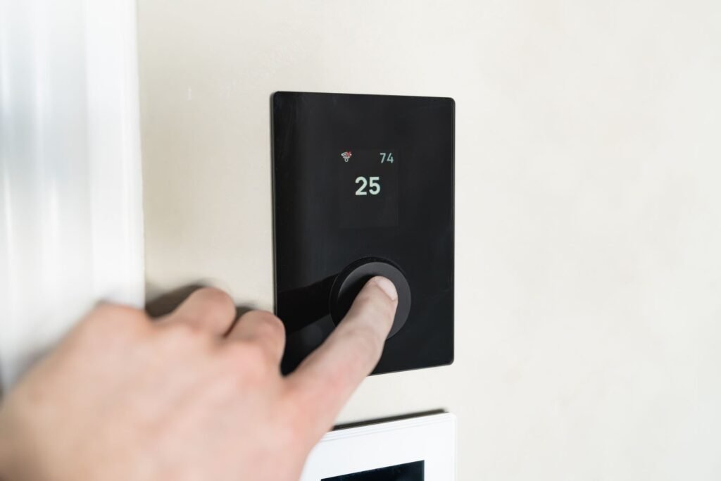 Homeowner adjusting a wall thermostat to control home heating