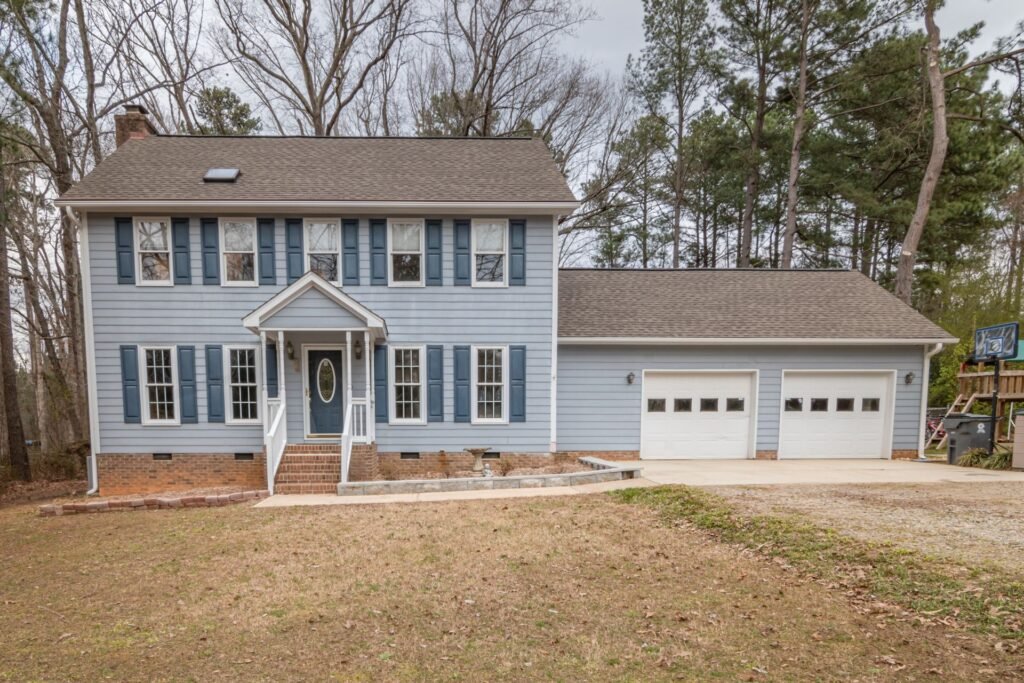 Two-story colonial home with attached garage, similar to homes in Carle Place, NY
